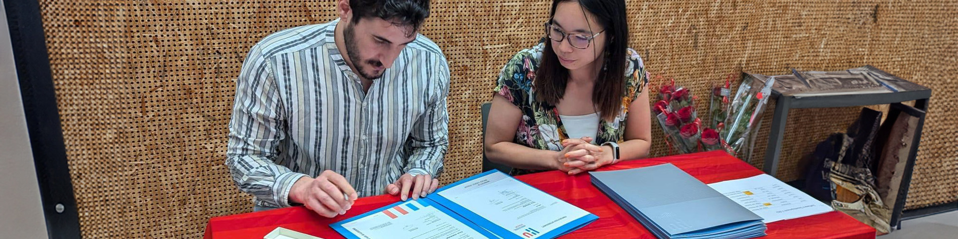 omar afstuderen, diploma ondertekenen aan tafel met docent